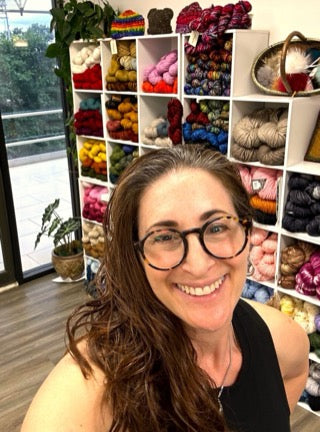 Ellen Rubin in front of the yarn shelves at Luv2Knit & More
